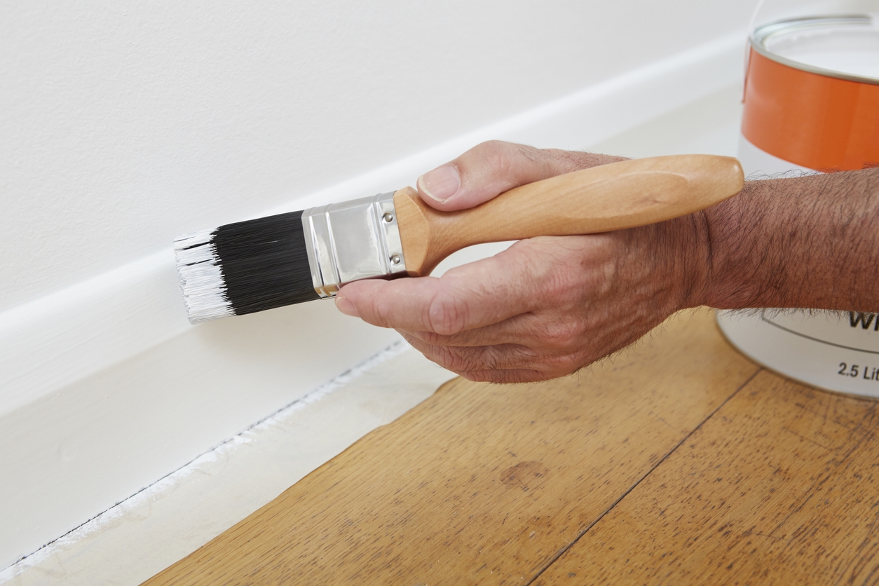 Close Up Of Man Painting painting trim with caulk in a Livermore home