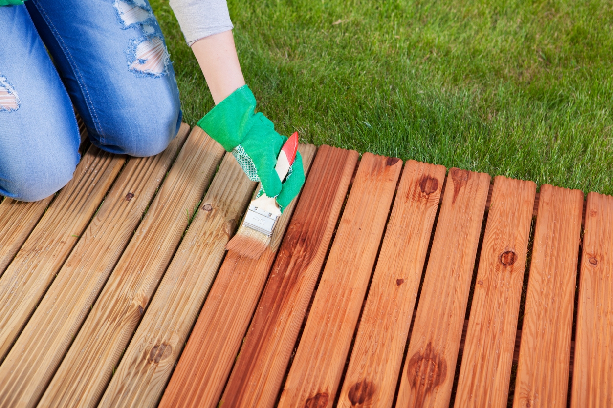 Applying protective varnish on a patio wooden deck in a Dublin, CA home