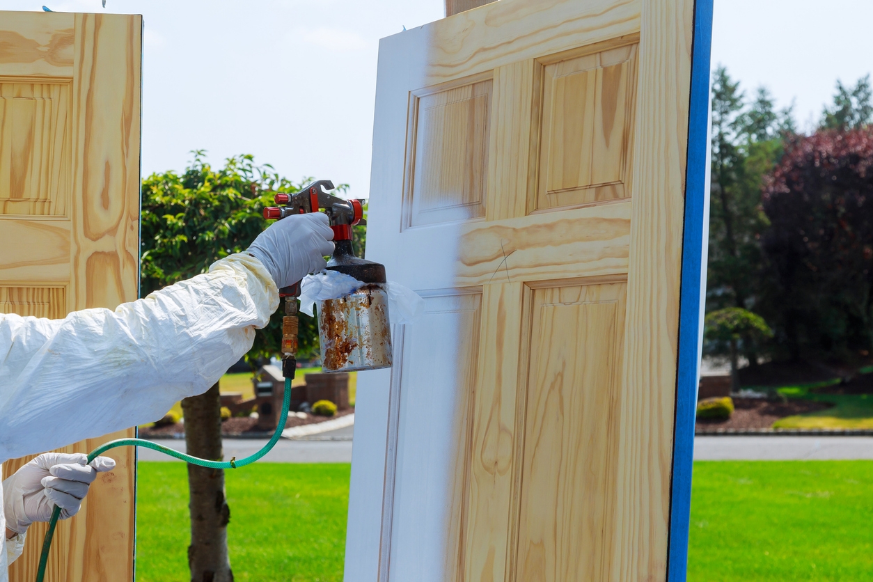 spray gun with paint painting Master painting wood doors